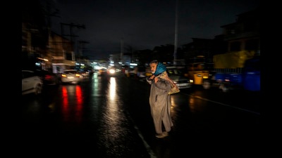 A man crosses a road on a cold and rainy evening in Srinagar on Wednesday, Nov. 9, 2022. (AP) A man crosses a road on a cold and rainy evening in Srinagar on Wednesday, Nov. 9, 2022. (AP)