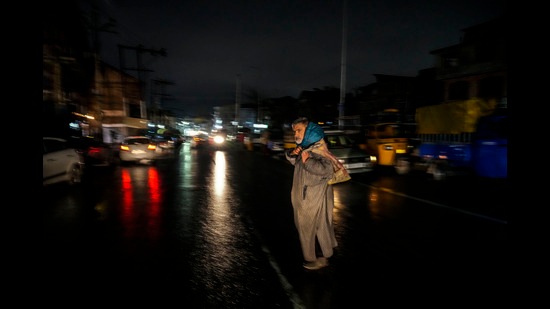 A man crosses a road on a cold and rainy evening in Srinagar on Wednesday, Nov. 9, 2022. (AP)