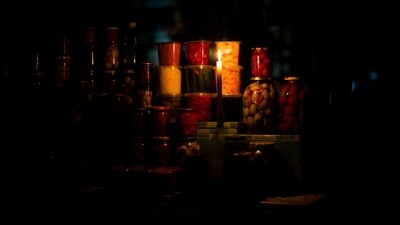 Russia-Ukraine War: A candle illuminates a market pickle food stall during a power outage in central Kyiv. (AP) Russia-Ukraine War: A candle illuminates a market pickle food stall during a power outage in central Kyiv. (AP)