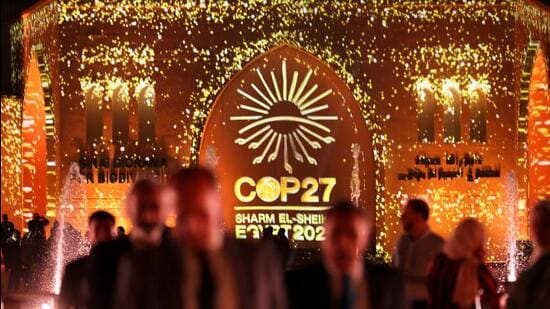 People pass in front of a wall lit with the sign of COP27 as the COP27 climate summit takes place, at the Green Zone in Sharm el-Sheikh, Egypt November 10, 2022. REUTERS/Mohamed Abd El Ghany (REUTERS)