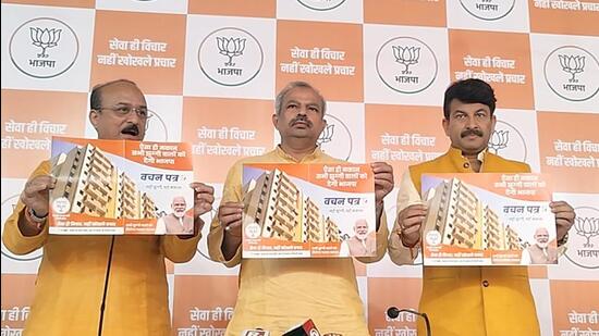 (from left) BJP leader Ashish Sood, Delhi BJP president Adesh Gupta and BJP MP Manoj Tiwari release the Vachan for the MCD elections on Thursday. (HT Photo)