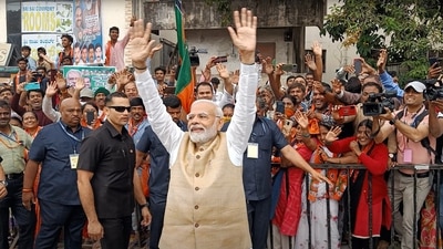 PM Modi waves to the people during a roadshow in Bengaluru. (ANI) 