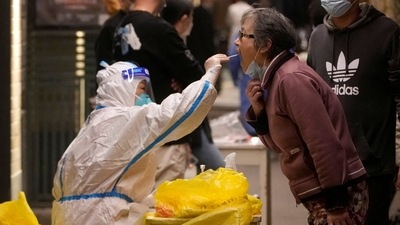 A medical worker in a protective suit collects a swab from a resident for nucleic acid testing, following the coronavirus disease (COVID-19) outbreak in Shanghai, China. (REUTERS)