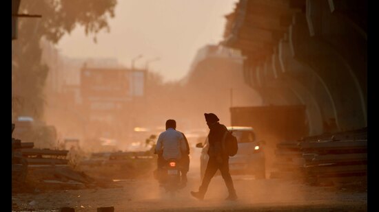 Commuters head home amid the smog and dust in Ludhiana on Friday. (Gurpreet Singh/HT)
