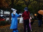 Covid In China: A worker in a protective suit guides people to scan health QR code at a nucleic acid test booth.