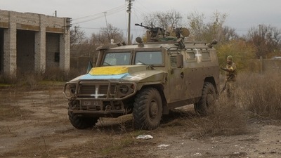 Russia-Ukraine War: A Ukrainian service member stands next to a previously captured Russian armoured personnel carrier. (Reuters)