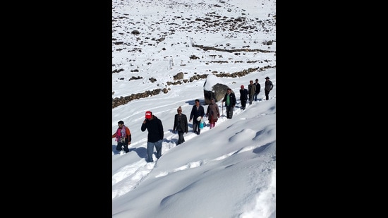 Voters moving through the snow to polling station at Chasak Bhatori in Pangi in Chamba district on Saturday. (HT Photo)