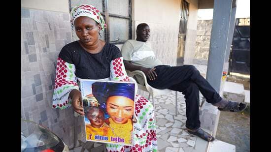 Mariama Kuyateh, 30, holds up a picture of her son Musa, who died of acute kidney failure, in Banjul on October 10, 2022. Gambian police have announced an investigation into four cough syrups made by the Indian Pharma company Maiden Pharmaceuticals, after the WHO said they could be responsible for the deaths of 66 Gambian children, most under five years old. (Milan Berckmans/AFP)