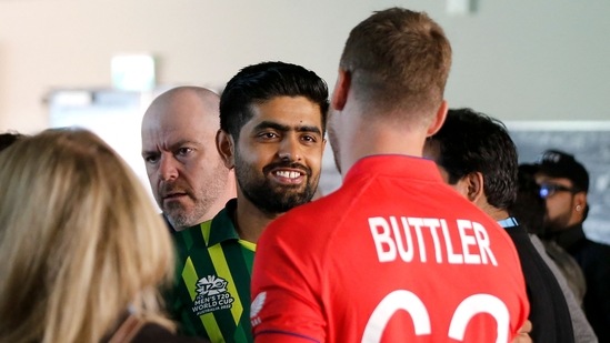 Pakistan's Captain Babar Azam (L) shakes hands with England's Captain Jos Buttler