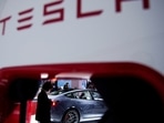 A Tesla electric vehicle (EV) is seen through a charging point displayed during a media day for the Auto Shanghai show in Shanghai, China April 20, 2021. REUTERS/Aly Song/File Photo