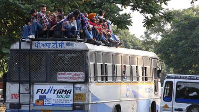 Commuters travel on roofs after more buses were deployed on interstate routes, in Chandigarh’s Sector 43 on Sunday. (HT Photo)