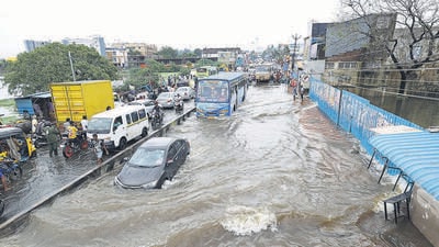 Vehicles ply through a waterlogged road following heavy rain near Chennai on Sunday. (PTI) Vehicles ply through a waterlogged road following heavy rain near Chennai on Sunday. (PTI)