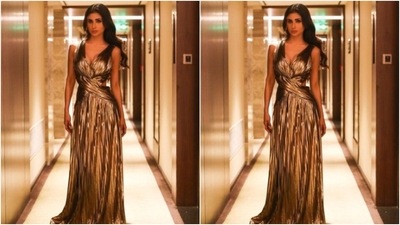 Mouni decked up in a golden metallic gown featuring sleeveless patterns with wrap around fabric details. It also came with a plunging neckline, cut out details at the sides and frill details below the waist. (Instagram/@imouniroy) Mouni decked up in a golden metallic gown featuring sleeveless patterns with wrap around fabric details. It also came with a plunging neckline, cut out details at the sides and frill details below the waist. (Instagram/@imouniroy)