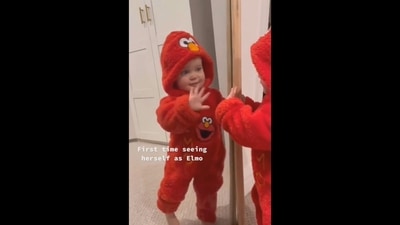 Andie Mae is waving at her mirror reflection. She is dressed as Elmo, a muppet character from Sesame Street. (Instagram/@goodnews_movement) Andie Mae is waving at her mirror reflection. She is dressed as Elmo, a muppet character from Sesame Street. (Instagram/@goodnews_movement)