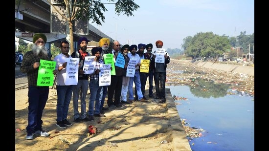 Environmentalists protesting against dumping of plastic in Sidhwan Canal, Ludhiana. (Harvinder Singh/HT)