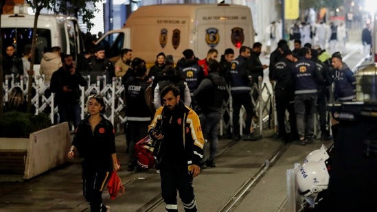 Emergency personnel walk away form the scene as forensic technicians keep working after an explosion on busy pedestrian Istiklal street in Istanbul. (Reuters)