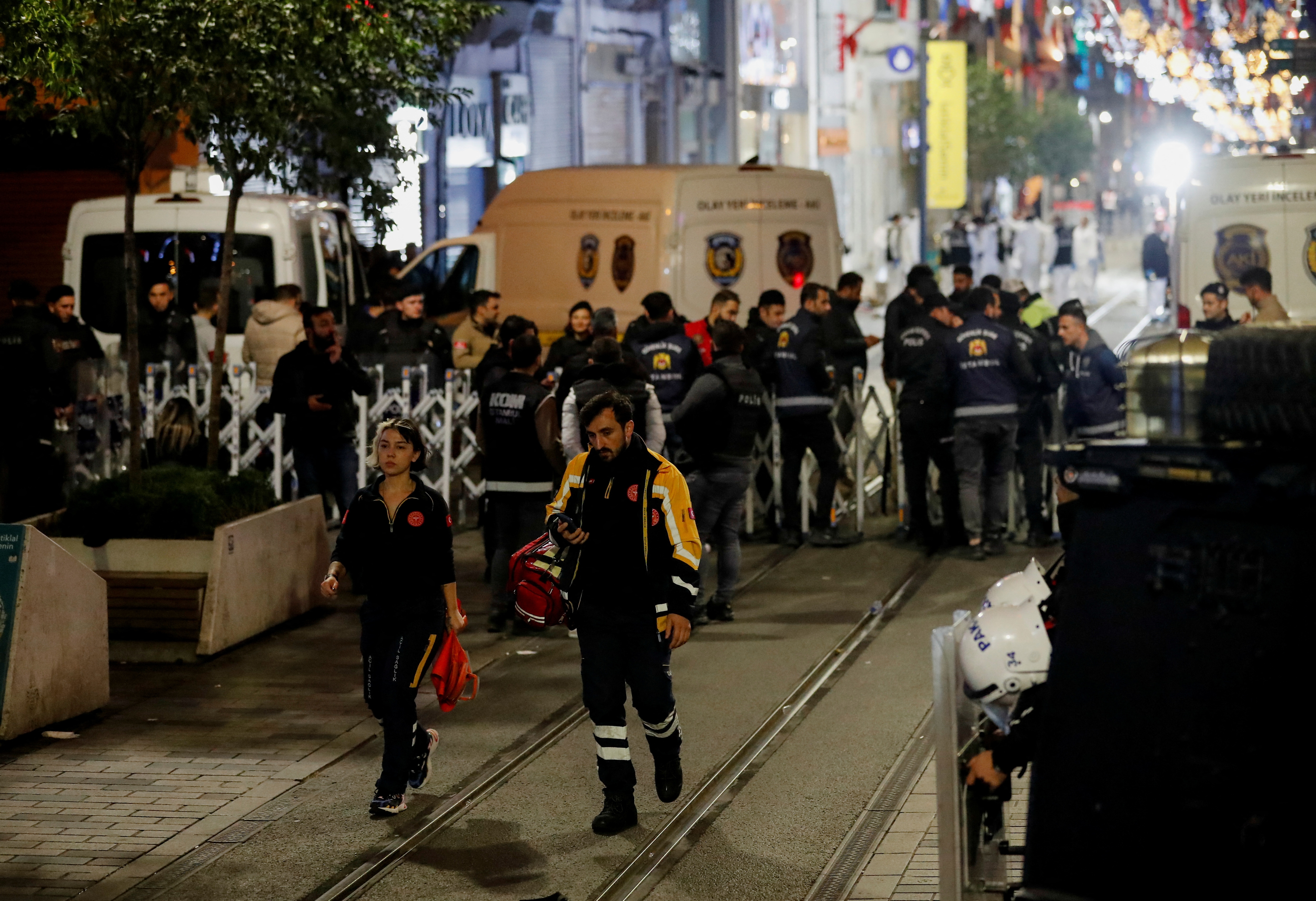 Emergency personnel walk away form the scene as forensic technicians keep working after an explosion on busy pedestrian Istiklal street in Istanbul. (Reuters)