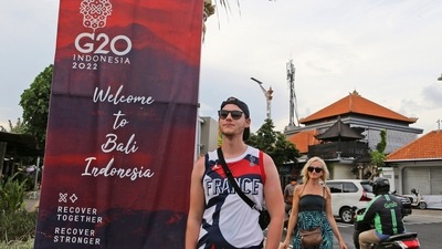 Tourists walk past a G20 banner in Nusa Dua, Bali, Indonesia. The dozens of world leaders and other dignitaries travelling to Bali for the G-20 summit will be drawing a welcome spotlight on the revival of the tropical island's ailing tourism sector after a two-year closure to foreign travelers due to the pandemic. (AP Photo/Firdia Lisnawati) Tourists walk past a G20 banner in Nusa Dua, Bali, Indonesia. The dozens of world leaders and other dignitaries travelling to Bali for the G-20 summit will be drawing a welcome spotlight on the revival of the tropical island's ailing tourism sector after a two-year closure to foreign travelers due to the pandemic. (AP Photo/Firdia Lisnawati)
