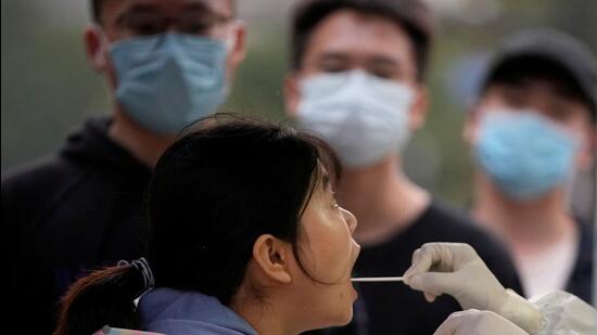 A woman gets tested at a nucleic acid testing site, following Covid-19 outbreak in Shanghai, China. (REUTERS)