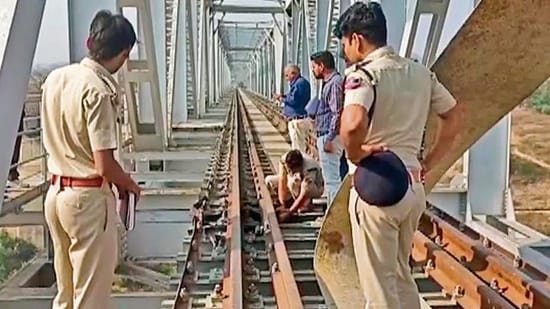 Police personnel inspect a site after an explosion occurred that led to cracks and broke flange on the track of the Udaipur-Ahmedabad rail line at Odha Railway bridge, in Udaipur on Sunday.