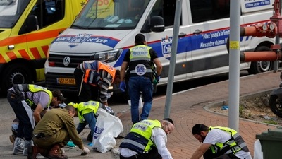 Members of an emergency response team and Israeli forces are seen. (Reuters)