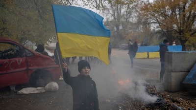 Russia-Ukraine War: A young boy waves a Ukrainian flag at a former Russian checkpoint. (AFP)