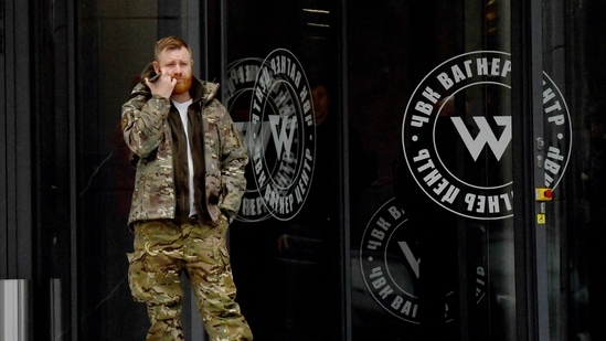 Russia-Ukraine War: A man wearing military camouflage stands at the entrance of the 'PMC Wagner Centre'. (AFP)