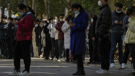 Covid In China: People wearing face masks stand in line for their routine COVID-19 tests.(AP) Covid In China: People wearing face masks stand in line for their routine COVID-19 tests.(AP)