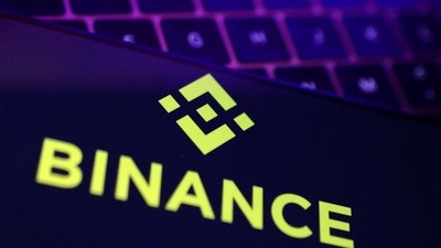 Binance logo and stock graph are displayed. (REUTERS)