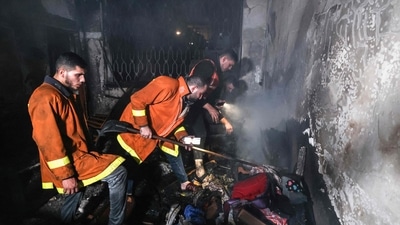 Palestinian firefighters extinguish a fire which broke out in one of the apartments in the Jabalia refugee camp in the northern Gaza strip, on November 17, 2022.. (AFP) Palestinian firefighters extinguish a fire which broke out in one of the apartments in the Jabalia refugee camp in the northern Gaza strip, on November 17, 2022.. (AFP)