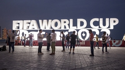 People are pictured in front of a FIFA World Cup Qatar 2022 sign ahead of the World Cup. (REUTERS)