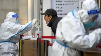 Covid In China: A worker wearing a protective suit swabs a man's throat for a COVID-19 test at a coronavirus testing site in Beijing. (AP) Covid In China: A worker wearing a protective suit swabs a man's throat for a COVID-19 test at a coronavirus testing site in Beijing. (AP)