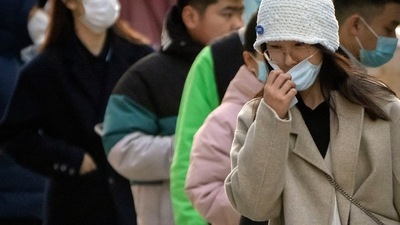 Covid In China: A woman adjusts her face mask after taking a COVID-19 test at a coronavirus testing site in Beijing. (AP)