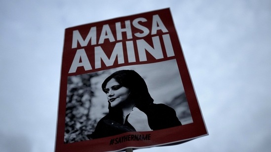 Iran Anti-Hijab Protests: A woman holds a placard with a picture of Iranian woman Mahsa Amini during a protest against her death.(AP) Iran Anti-Hijab Protests: A woman holds a placard with a picture of Iranian woman Mahsa Amini during a protest against her death.(AP)