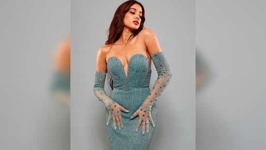 Adding a vintage touch to her look, Janhvi Kapoor teamed her glamorous silhouette with a pair of netted blue gloves.(Instagram/@janhvikapoor)