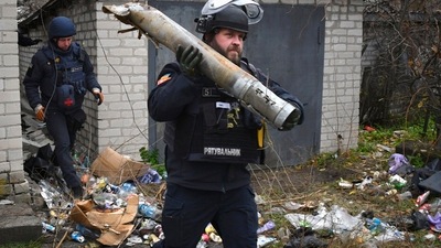 Russia-Ukraine War: A Ukrainian sapper carries a part of a projectile. (AP) Russia-Ukraine War: A Ukrainian sapper carries a part of a projectile. (AP)