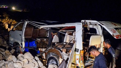 Pakistan Accident: A policeman stands beside a damaged passenger mini bus. (AFP)