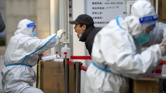 Covid In China: A worker wearing a protective suit swabs a man's throat for a COVID-19 test at a coronavirus testing site in Beijing. (AP)
