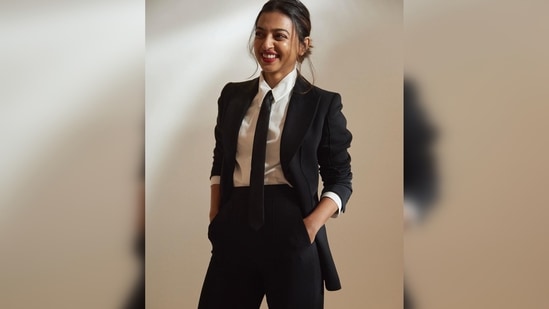 Radhika Apte's outfit comes with a black blazer, high-rise black trousers, a white shirt and a black tie.(Instagram/@radhikaofficial)