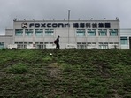 This file photo taken on May 6, 2022 shows a man walking past the Foxconn headquarters in Tucheng district, New Taipei City. Taiwanese electronics giant and iPhone manufacturer Foxconn warned that its last quarter earnings this year would take a hit from the coronavirus lockdowns affecting its assembly lines in the Chinese city of Zhengzhou.(AFP) This file photo taken on May 6, 2022 shows a man walking past the Foxconn headquarters in Tucheng district, New Taipei City. Taiwanese electronics giant and iPhone manufacturer Foxconn warned that its last quarter earnings this year would take a hit from the coronavirus lockdowns affecting its assembly lines in the Chinese city of Zhengzhou.(AFP)