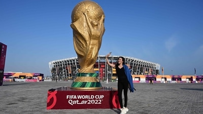 A woman takes a selfie with her mobile phone beside a giant replica of the FIFA World Cup trophy in front of the Stadium 974 in Doha A woman takes a selfie with her mobile phone beside a giant replica of the FIFA World Cup trophy in front of the Stadium 974 in Doha