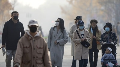 Covid In China: People wearing face masks walk along a pedestrian shopping street at the Wangfujing shopping district in Beijing. (AP) Covid In China: People wearing face masks walk along a pedestrian shopping street at the Wangfujing shopping district in Beijing. (AP)
