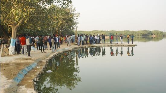 Media personnel and local residents near the pond where Aftab Poonawala is suspected to have dumped Shraddha Walkar's head, at Chhatarpur in New Delhi on November 20. (PTI)