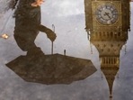 UK Weather: A woman with an umbrella and the Elizabeth Tower also known as Big Ben are reflected in a puddle in London.(AP) UK Weather: A woman with an umbrella and the Elizabeth Tower also known as Big Ben are reflected in a puddle in London.(AP)