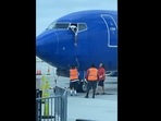 Pilot leaning out of plane's window to get passenger's forgotten phone from crew. (Facebook/Southwest Airlines) Pilot leaning out of plane's window to get passenger's forgotten phone from crew. (Facebook/Southwest Airlines)