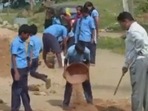 Screengrab from the viral video of school students filling potholes. Screengrab from the viral video of school students filling potholes.
