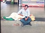 The man pats his wife as she rests her head in his lap. The man pats his wife as she rests her head in his lap.