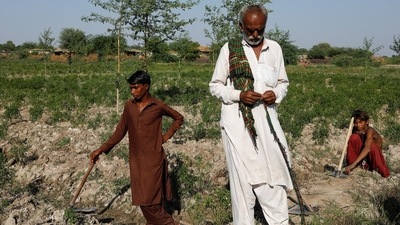 Farmers on a break from preparing the soil after heavy floods in Kunri, on October 15. Before the floods, rising temperatures in the area had made it harder to grow chili, which needs more moderate conditions. (Akhtar Soomro / REUTERS)