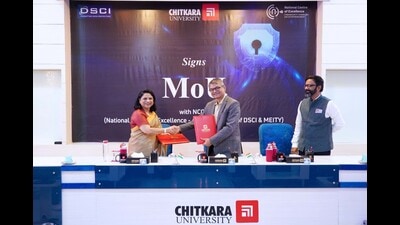 Madhu Chitkara, pro-chancellor, Chitkara University, and Vinayak Godse, CEO, DSCI, exchanging documents after signing the agreement. (HT Photo)