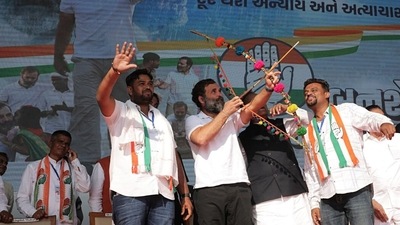 Congress leader Rahul Gandhi holds a bow and an arrow during the public meeting for the upcoming Gujarat Assembly elections, in Surat. (ANI)